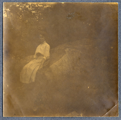 Photograph of a woman sitting on a rock