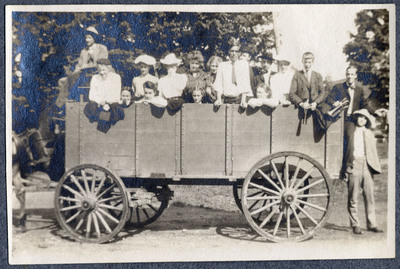 Photograph of a group of people in a large horse-drawn carriage