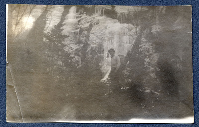 Photograph of unidentified men in front of a waterfall