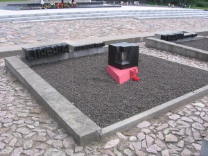 A representation of a missing village, with some dirt or other material from the village in the central container, sitting on red fire.  